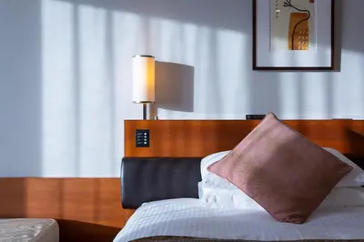 a bedroom with a bed with a pillow and a lamp at MAIHAMA VIEW HOTEL by HULIC Formerly Tokyo Bay Maihama Hotel in Urayasu