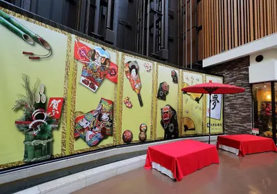 a wall with paintings on it with two tables and an umbrella at MAIHAMA VIEW HOTEL by HULIC Formerly Tokyo Bay Maihama Hotel in Urayasu