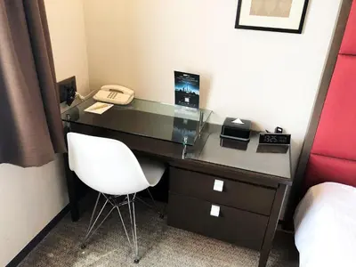 a desk with a phone and a chair in a room at Citadines Central Shinjuku Tokyo in Tokyo