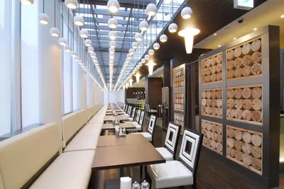 a dining room with tables and chairs and a wall of wine barrels at Citadines Central Shinjuku Tokyo in Tokyo