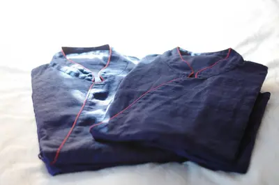 a pair of jeans sitting on top of a bed at HOTEL AMANEK Ginza East in Tokyo