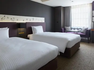a hotel room with two beds and a table at Mitsui Garden Hotel Kyobashi - Tokyo Station in Tokyo