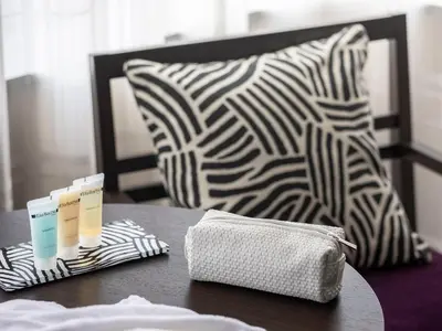 a table with a bed and a pillow and a table with a table at Mitsui Garden Hotel Kyobashi - Tokyo Station in Tokyo