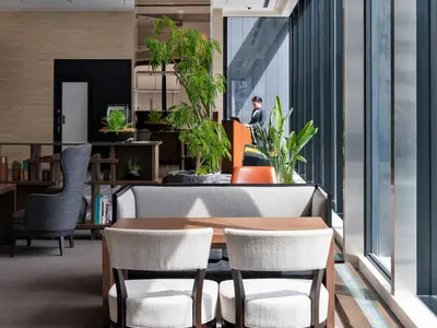 a table and chairs in an office with plants at Mitsui Garden Hotel Kyobashi - Tokyo Station in Tokyo