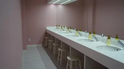 a long row of sinks in a bathroom with stools at Akihabara Bay Hotel (Female Only) in Tokyo