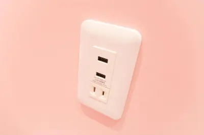 a white electrical outlet on a pink wall at Akihabara Bay Hotel (Female Only) in Tokyo