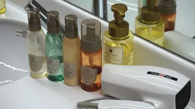 a counter with a bunch of bottles of oils at Akihabara Bay Hotel (Female Only) in Tokyo