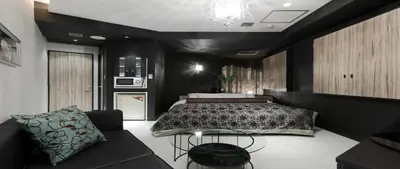 a bedroom with a bed and a couch at Hotel VARKIN in Tokyo