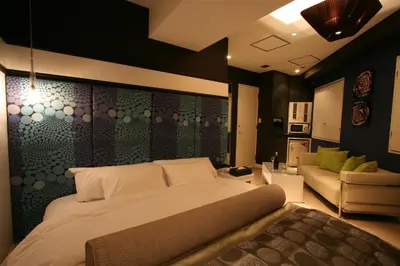 a bedroom with a large bed and a couch at Hotel VARKIN in Tokyo