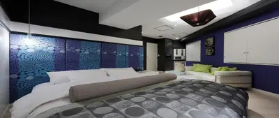 a bedroom with a large bed and a blue wall at Hotel VARKIN in Tokyo