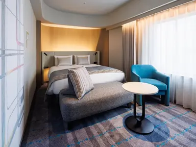 a hotel room with a bed and a chair at Hotel Metropolitan Tokyo Ikebukuro in Tokyo
