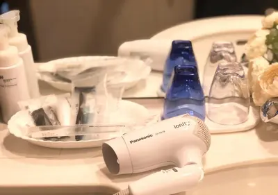 a table with a hair dryer and bottles on it at Hotel Metropolitan Tokyo Ikebukuro in Tokyo