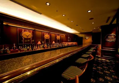 a bar in a hotel with a long counter and chairs at Hotel Metropolitan Tokyo Ikebukuro in Tokyo
