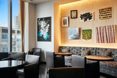 a restaurant with tables and chairs and a window at Park Hotel Tokyo in Tokyo
