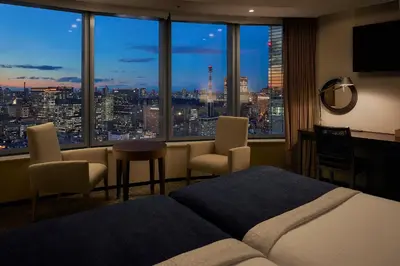 a bedroom with a view of a city skyline at Park Hotel Tokyo in Tokyo