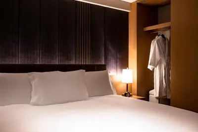 a bed with white pillows and a lamp in a room at The Strings by InterContinental, Tokyo by IHG in Tokyo