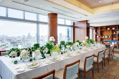 a long table with flowers in a room with windows at The Strings by InterContinental, Tokyo by IHG in Tokyo