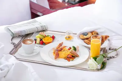 a tray of breakfast foods and coffee on a bed at The Strings by InterContinental, Tokyo by IHG in Tokyo