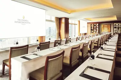 a long row of tables and chairs in a restaurant at The Strings by InterContinental, Tokyo by IHG in Tokyo