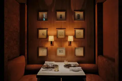 a dining room with a table and a wall with pictures at Park Hyatt Tokyo in Tokyo
