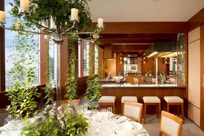 a dining room with a table and a kitchen at Park Hyatt Tokyo in Tokyo