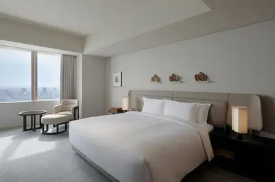 a hotel room with a large white bed and a window at Park Hyatt Tokyo in Tokyo