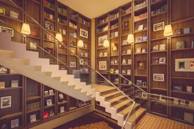 a staircase in a library with bookshelves at Shiba Park Hotel in Tokyo