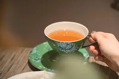 a person holding a cup of tea on a table at Shiba Park Hotel in Tokyo