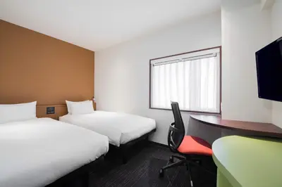 a room with two beds and a desk and a computer at the b akasaka in Tokyo