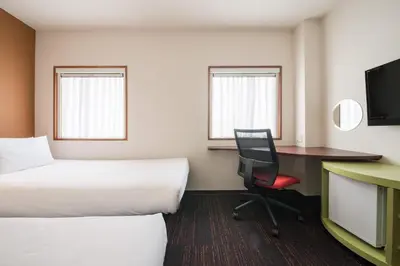 a hotel room with two beds and a desk and a computer at the b akasaka in Tokyo