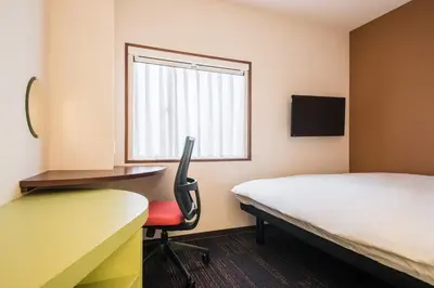 a room with a bed and a desk and a chair at the b akasaka in Tokyo