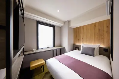 a bedroom with a large bed and a window at the b ochanomizu in Tokyo