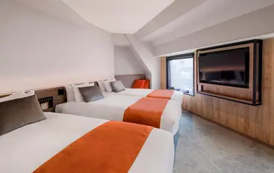 a hotel room with two beds and a tv at the b ochanomizu in Tokyo