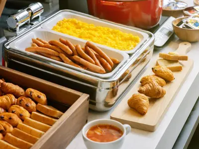 a buffet of food with hot dogs and croissants and dip at the b ochanomizu in Tokyo