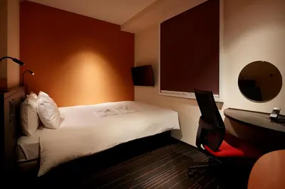 a hotel room with a white bed and a desk at the b akasaka-mitsuke in Tokyo