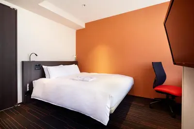 a bedroom with a white bed and a red chair at the b akasaka-mitsuke in Tokyo