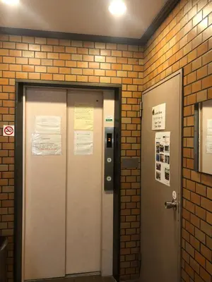 a pair of elevators in a brick wall at Hotel Yanagibashi in Tokyo