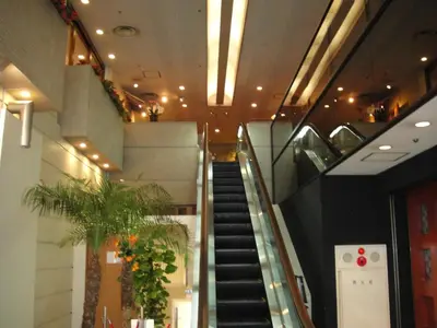 a spiral staircase in a building with a plant at Daiichi Inn Ikebukuro in Tokyo