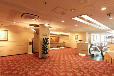 a lobby with a waiting room with a potted plant at Daiichi Inn Ikebukuro in Tokyo