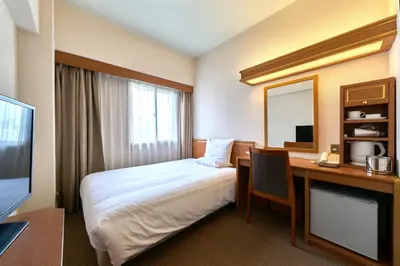 a hotel room with a bed and a desk at Daiichi Inn Ikebukuro in Tokyo