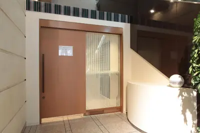 a brown door with a window in a building at Daiichi Inn Ikebukuro in Tokyo