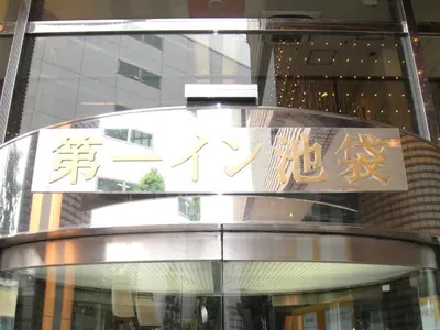 a sign on top of a revolving door in front of a building at Daiichi Inn Ikebukuro in Tokyo