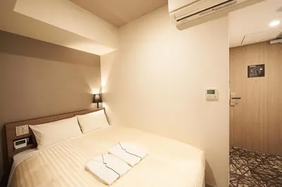 a bedroom with a bed with two pillows on it at Sotetsu Fresa Inn Ginza-Nanachome in Tokyo