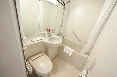 a small bathroom with a toilet and a sink at Sotetsu Fresa Inn Ginza-Nanachome in Tokyo