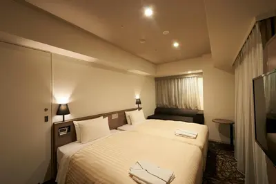 a hotel room with a bed with two towels on it at Sotetsu Fresa Inn Ginza-Nanachome in Tokyo