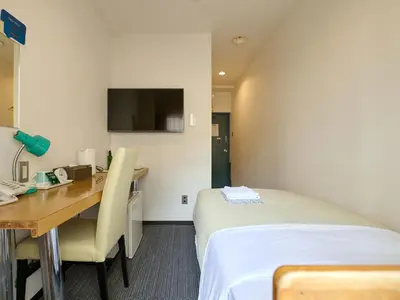 a hotel room with a bed and a desk and a television at Tabist Hotel Tetora Ikebukuro in Tokyo