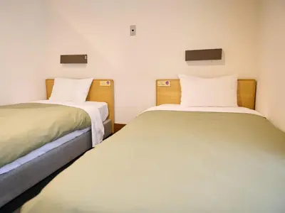 two beds sitting next to each other in a room at Tabist Hotel Tetora Ikebukuro in Tokyo