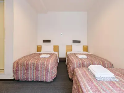 two twin beds in a room with at Tabist Hotel Tetora Ikebukuro in Tokyo