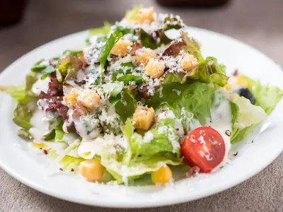 a salad on a white plate on a table at APA Hotel Ochanomizu Ekikita in Tokyo