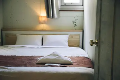 a bedroom with a bed with a pillow on it at Nui. HOSTEL & BAR LOUNGE in Tokyo